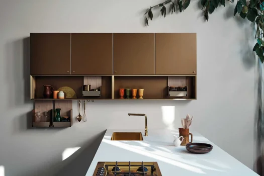 Cucina Cesar MAXIMA 2.2 STYLISH FLARE moderna con armadietti marroni e piano bianco, design minimalista e stoviglie colorate.