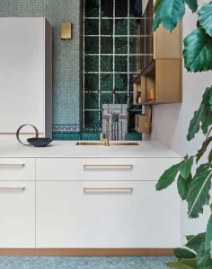 Cucina cesar MAXIMA 2.2 STYLISH FLARE moderna con piastrelle verdi, armadietti bianchi e dettagli in ottone, perfetta per un design elegante e contemporaneo.